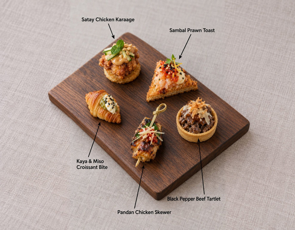 The Singapore Table canapes on a wooden board, labelled Satay Chicken Karaage and 4 more. Cuseho canape catering, Singapore