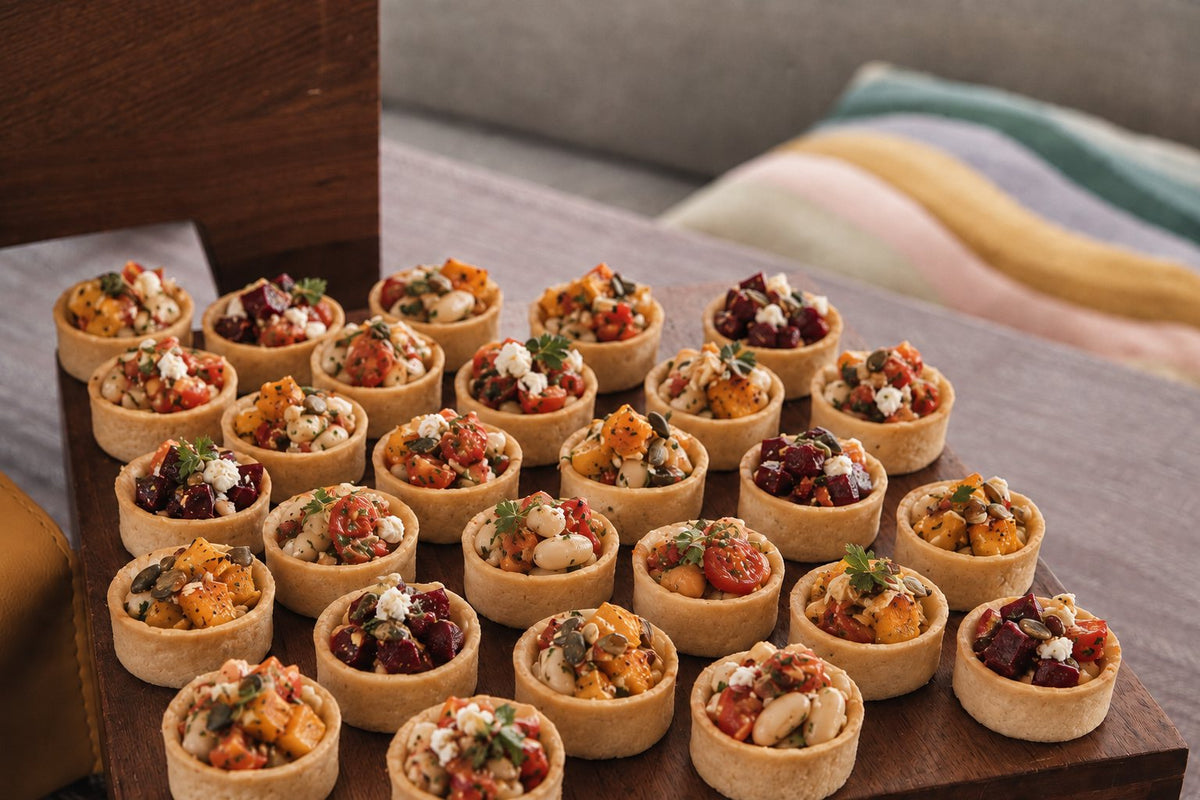 Roasted vegetable and feta tartlets on a wooden serving board. Cuseho canape catering, Singapore