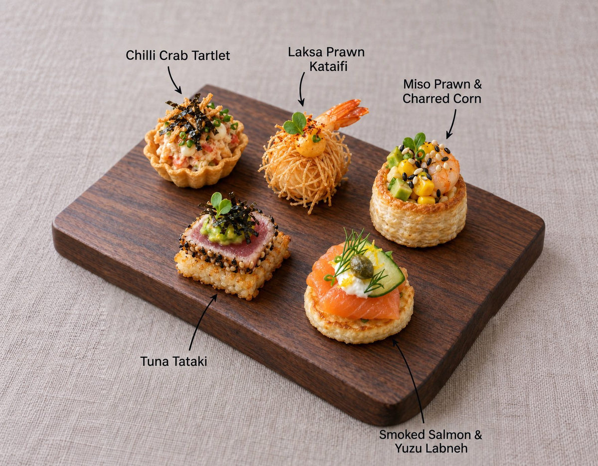 The Sea canapes on a wooden board, labelled Chilli Crab Tartlet and 4 more. Cuseho canape catering, Singapore