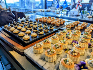 Chef plating caviar canapes and vol-au-vents at the station. Cuseho appetisers live station catering, Singapore
