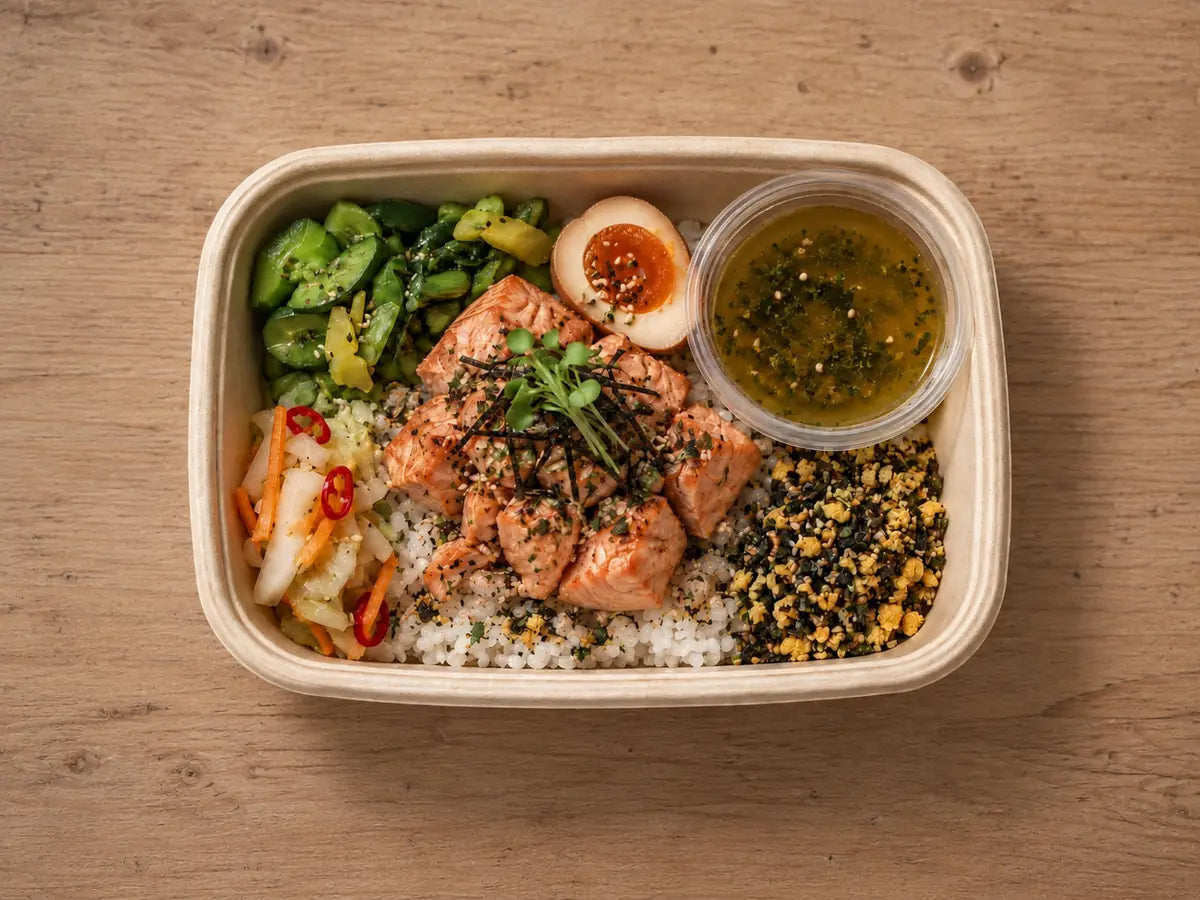 Salmon ochazuke rice bento with a soft egg, pickles and dashi in a kraft box. Cuseho bento catering, Singapore