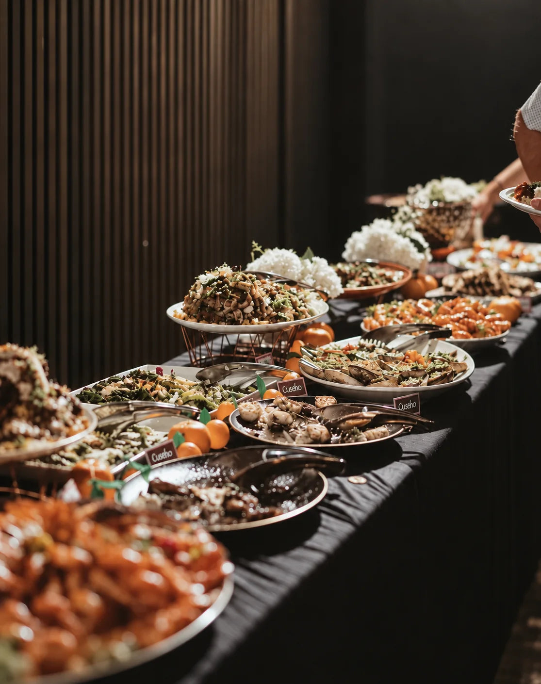 Long buffet table with a guest serving food