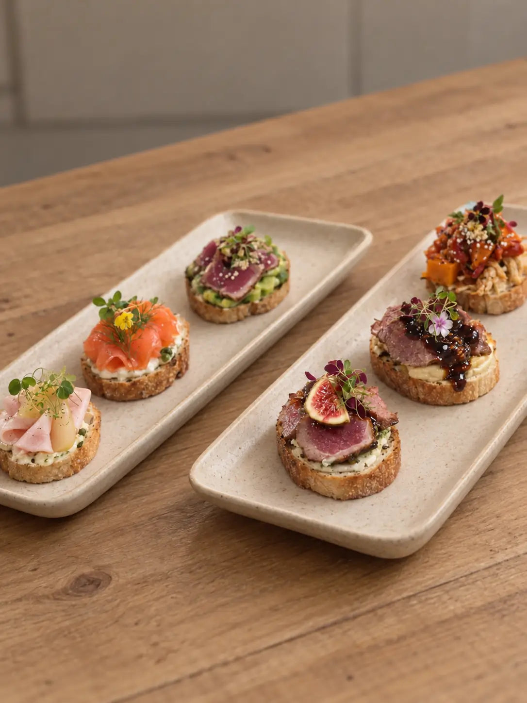 Salmon, tuna tataki, chicken ham, smoked duck and roast beef crostini on grey trays. Cuseho tea break catering, Singapore